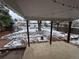 Covered patio with string lights overlooking the expansive backyard and mature trees covered in snow at 3770 S Ulster St, Denver, CO 80237