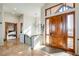 Bright foyer with wood paneled door, tile floors, modern light fixture, and fireplace detail in the background at 2430 Marlin Way, Castle Rock, CO 80109