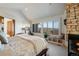 Serene main bedroom with stone fireplace, bench seating, and windows framing picturesque mountain views at 2430 Marlin Way, Castle Rock, CO 80109