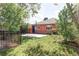 Brick home featuring a patio and fenced yard, surrounded by mature trees for added privacy and shade at 1610 Xanthia St, Denver, CO 80220