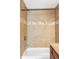 Cozy bathroom with white tub and shower showcasing tiled walls and neutral accents at 1610 Xanthia St, Denver, CO 80220