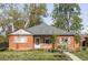 Charming brick home featuring a well-maintained front yard, blossoming trees, and cozy curb appeal at 1610 Xanthia St, Denver, CO 80220