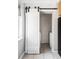 Efficient laundry room featuring barn door entrance and modern tile flooring at 1610 Xanthia St, Denver, CO 80220