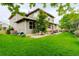 Spacious backyard featuring a lush lawn, mature trees, and a patio area, ideal for outdoor entertaining at 14200 W 86Th Pl, Arvada, CO 80005