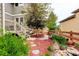 Secluded backyard with stepping stones, mulched garden beds, and a wooden fence, creating a peaceful retreat at 14200 W 86Th Pl, Arvada, CO 80005