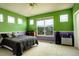 Vibrant bedroom with green walls, large windows, and a cozy bed, creating a cheerful and inviting space at 14200 W 86Th Pl, Arvada, CO 80005