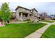 Beautifully landscaped front yard with lush green lawn, sidewalk, and inviting exterior at 14200 W 86Th Pl, Arvada, CO 80005