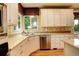 Bright kitchen area featuring white cabinetry, stainless steel appliances, and a window overlooking the backyard at 14200 W 86Th Pl, Arvada, CO 80005