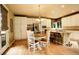 Eat-in kitchen with a central island, white cabinets, stainless appliances, and hardwood flooring, open to the dining area at 14200 W 86Th Pl, Arvada, CO 80005