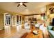 Bright living room boasts hardwood floors, a ceiling fan, and access to the kitchen and outdoor patio at 14200 W 86Th Pl, Arvada, CO 80005