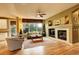 Inviting living room with a fireplace, a ceiling fan, and abundant natural light from the expansive windows at 14200 W 86Th Pl, Arvada, CO 80005