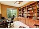 Comfortable home office features a large window and custom built-in shelving for ample storage and organization at 14200 W 86Th Pl, Arvada, CO 80005