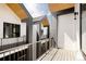 Modern balcony boasts black railings, wooden accents, and a view of neighboring units under a bright sky at 8260 E 36Th Ave # 30, Denver, CO 80238