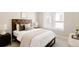 Cozy bedroom with a dark wood headboard, neutral bedding, and a bright window at 8260 E 36Th Ave # 30, Denver, CO 80238