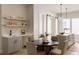 Open dining area with a stylish round table, modern chairs, floating shelves, and a convenient bar area at 8260 E 36Th Ave # 30, Denver, CO 80238