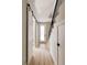 Hallway with wood floors, sliding barn doors, and a staircase with a black railing at 8260 E 36Th Ave # 30, Denver, CO 80238