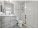Modern bathroom featuring gray cabinets, white tile, glass shower, and contemporary fixtures at 1064 Depew St, Lakewood, CO 80214