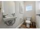 Powder bath with hardwood floors, floating sink, toilet, modern mirror and an abstract art piece at 1064 Depew St, Lakewood, CO 80214
