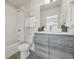 Modern bathroom with shower and tub combo, vanity and gray wood-look cabinets at 1064 Depew St, Lakewood, CO 80214
