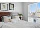Bright bedroom featuring a large bed with decorative pillows and natural light streaming through window at 1064 Depew St, Lakewood, CO 80214