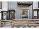 Modern townhome entrance featuring a stylish door, house number, and a charming wooden fence at 1064 Depew St, Lakewood, CO 80214