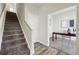 Hallway with staircase leading to a home office featuring a modern desk and neutral decor at 1064 Depew St, Lakewood, CO 80214