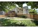 Expansive backyard featuring lush grass, a wooden deck and pergola, and a charming stone pathway at 8258 S Reed Way, Littleton, CO 80128
