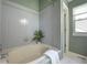 Clean and stylish bathroom features tiled walls, a large soaking tub, a decorative plant, and natural light at 8258 S Reed Way, Littleton, CO 80128