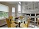 Bright dining area with seating for four, glass table, hardwood floors and overlooking living area at 8258 S Reed Way, Littleton, CO 80128
