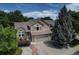 Beautifully landscaped home with a two-car garage, complemented by mature trees and a stone pathway at 8258 S Reed Way, Littleton, CO 80128