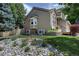 Exterior side view with rock garden, manicured lawn, and mature landscaping at 8258 S Reed Way, Littleton, CO 80128