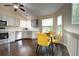 Bright eat-in kitchen featuring stainless appliances, light gray cabinetry, and modern lighting fixture above the sink at 8258 S Reed Way, Littleton, CO 80128