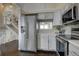 Bright kitchen featuring stainless steel appliances, white cabinets, and hardwood flooring at 8258 S Reed Way, Littleton, CO 80128