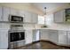 Modern kitchen with stainless steel appliances, white cabinetry, and sleek countertops at 8258 S Reed Way, Littleton, CO 80128