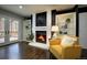 Inviting living room with a cozy fireplace, built-in shelving, hardwood floors, and a doorway to the outdoor deck at 8258 S Reed Way, Littleton, CO 80128