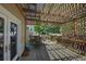 Outdoor patio with a lattice roof, table, chairs, and a view of the backyard at 8258 S Reed Way, Littleton, CO 80128