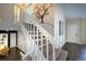 Carpeted staircase with white railings, a stylish tree mural, and hardwood floors on the landing and hallways at 8258 S Reed Way, Littleton, CO 80128