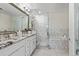 Bathroom featuring double sinks, granite counters, and tiled bath and shower at 2500 E Cherry Creek South Dr # 313, Denver, CO 80209