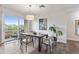 Bright dining room with hardwood floors, modern lighting, and a sliding glass door to the balcony at 2500 E Cherry Creek South Dr # 313, Denver, CO 80209