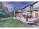 Expansive backyard with a stone patio, lush lawn, and mature trees, ideal for relaxation at 10459 Rivington Ct, Lone Tree, CO 80124