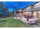 Lush backyard with a stone patio with multiple dining and lounge seating around the fireplace; great for entertaining at 10459 Rivington Ct, Lone Tree, CO 80124