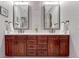 Elegant bathroom featuring dual sinks, granite countertop, and rich wood cabinetry at 10459 Rivington Ct, Lone Tree, CO 80124