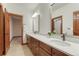 Bright bathroom with double vanity, granite countertops and dark wood cabinets at 10459 Rivington Ct, Lone Tree, CO 80124