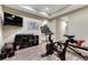 Home gym features exercise equipment and a large TV, set against neutral walls and wood-look flooring at 10459 Rivington Ct, Lone Tree, CO 80124