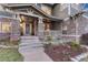 Inviting front porch with stone accents, manicured landscaping, and a welcoming entrance at 10459 Rivington Ct, Lone Tree, CO 80124