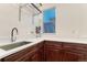 Bright laundry room features custom cabinets, quartz countertops, stainless steel sink, and convenient shelving at 10459 Rivington Ct, Lone Tree, CO 80124