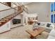 Spacious living room with a staircase, stone fireplace, and an adjacent kitchen at 10459 Rivington Ct, Lone Tree, CO 80124
