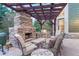 Inviting outdoor patio area with a stone fireplace, pergola, and comfortable seating at 10459 Rivington Ct, Lone Tree, CO 80124