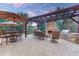 Cozy outdoor patio with a stone fireplace, pergola, dining set, and grill, perfect for entertaining at 10459 Rivington Ct, Lone Tree, CO 80124