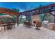 Inviting outdoor patio with a stone fireplace, grill, and comfortable seating, perfect for outdoor living at 10459 Rivington Ct, Lone Tree, CO 80124